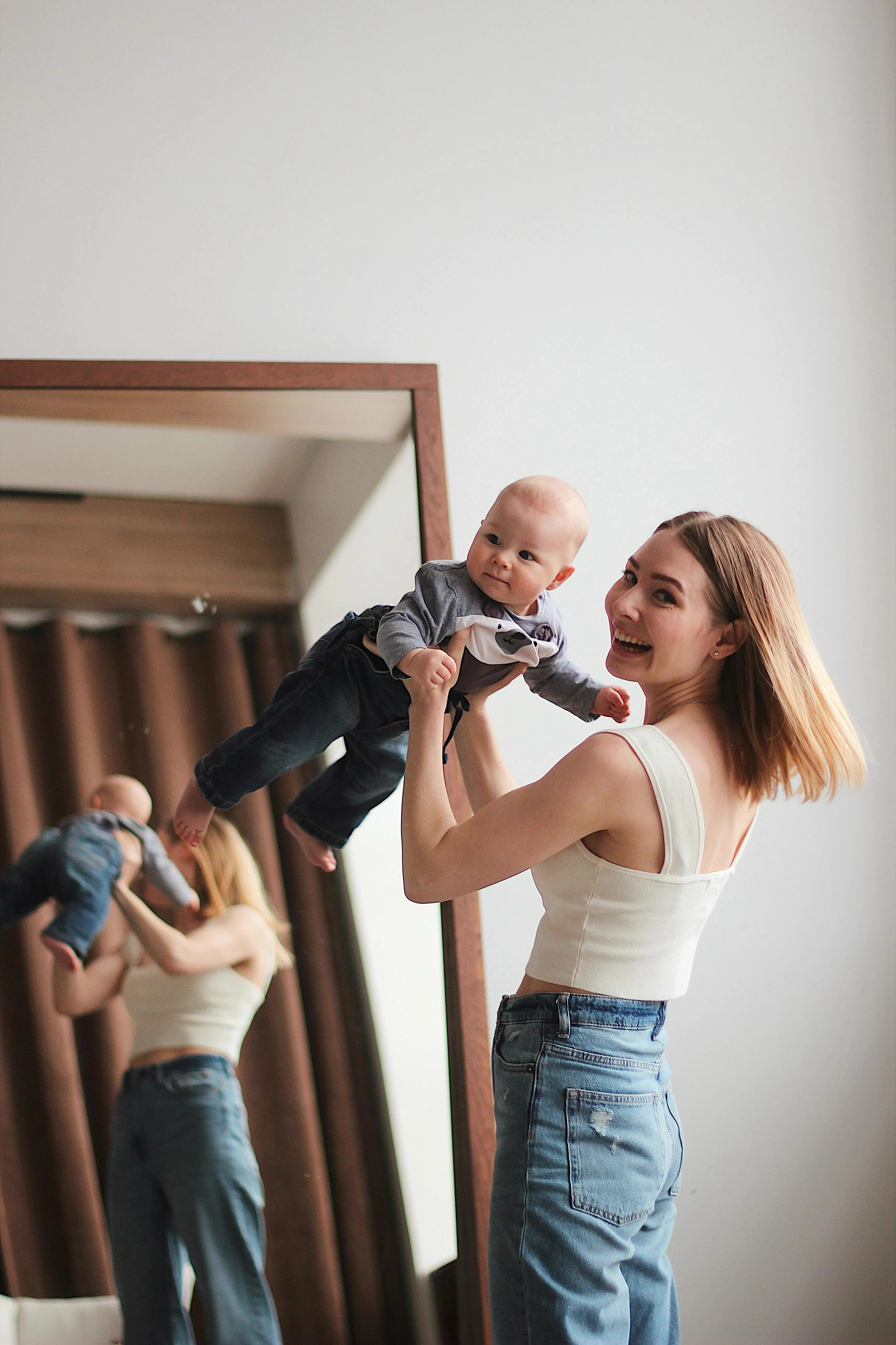 Une femme et son bébé devant un miroir